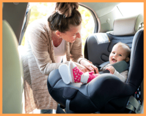 Image of a happy family with a baby in a car seat, showcasing the importance of safe travel for infants.